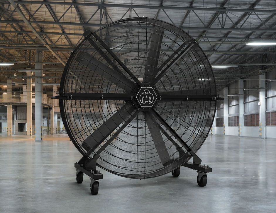 Mobiler ecoBreezer® AirMax Großventilator mit schwarzen Rotorblättern in einer weitläufigen Industriehalle